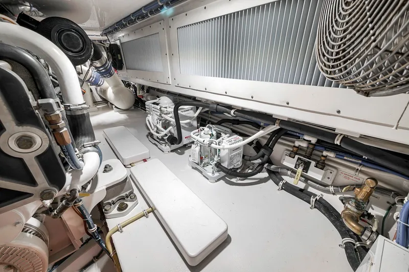 Slide: The Image of Engine room of 2021 Hatteras GT65 Carolina yacht, showcasing mechanical components and piping. - 56