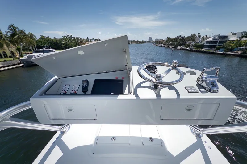 Slide: The Image of 2021 Hatteras GT65 Carolina yacht helm with steering wheel and controls on a sunny day. - 27