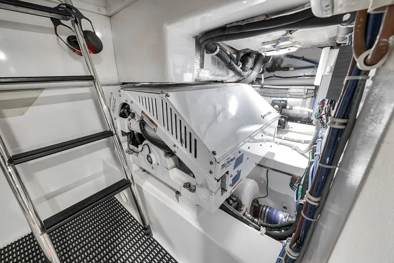 Slide: The Image of Engine room of 2021 Hatteras GT65 Carolina yacht, featuring machinery and ladder. - 61