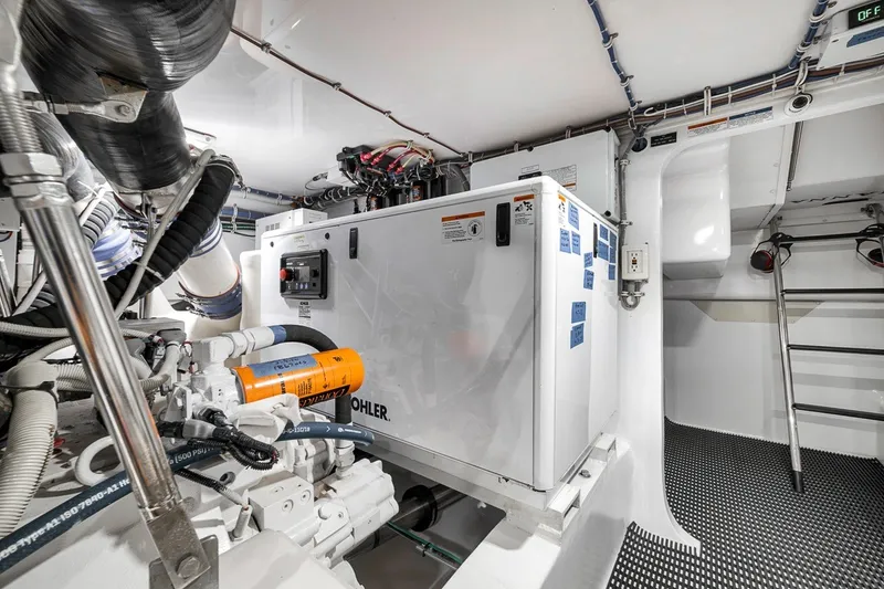 Slide: The Image of Engine room of 2021 Hatteras GT65 Carolina yacht, featuring Kohler generator and advanced equipment. - 58