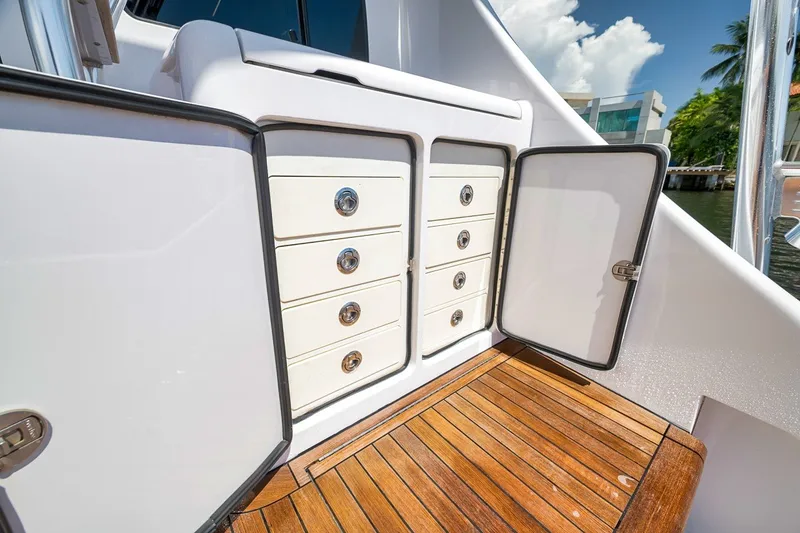 Slide: The Image of 2021 Hatteras GT65 Carolina yacht storage with open cabinets and wooden deck. - 14