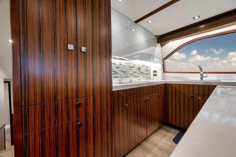 Slide: The Image of Luxurious kitchen interior of 2021 Hatteras GT65 Carolina yacht with wood cabinetry and ocean view. - 35