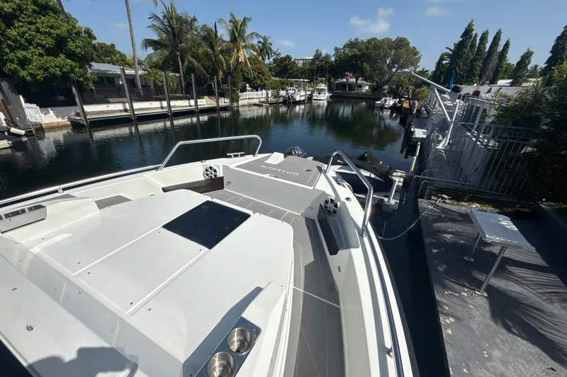 Slide: The Image of 2024 Quarken 35 Cabin Tourer docked by a serene waterfront with lush greenery. - 26