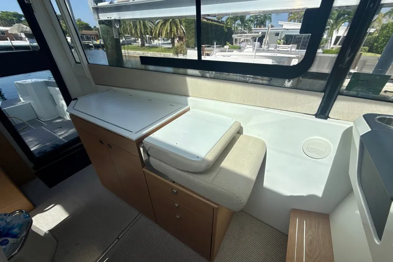 Slide: The Image of Interior of 2024 Quarken 35 Cabin Tourer, featuring seating and storage with marina view. - 19