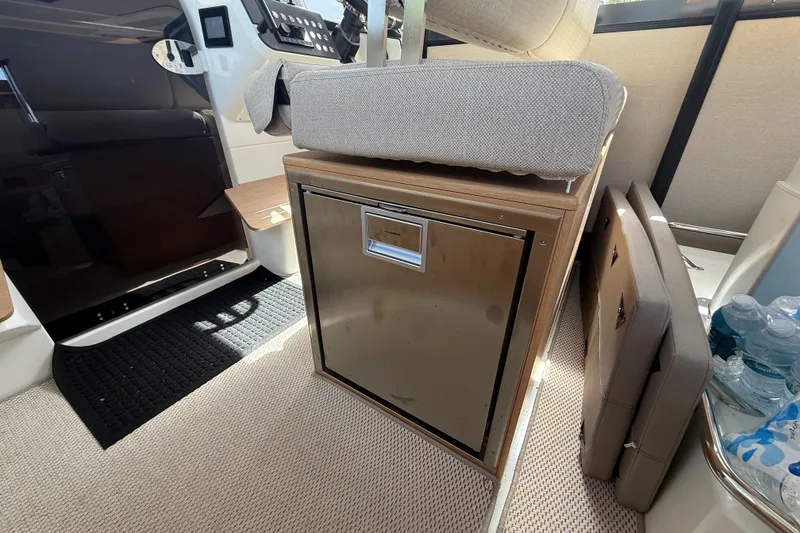 Slide: The Image of Interior of 2024 Quarken 35 Cabin Tourer, featuring a compact fridge and seating area. - 15