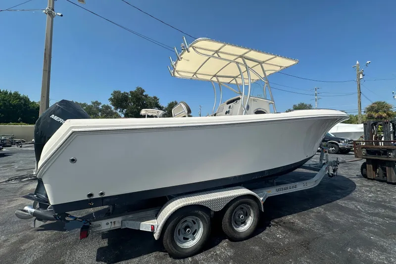 Slide: The Image of 2023 Sailfish 242 CC boat on trailer, featuring a sleek design and T-top canopy. - 5