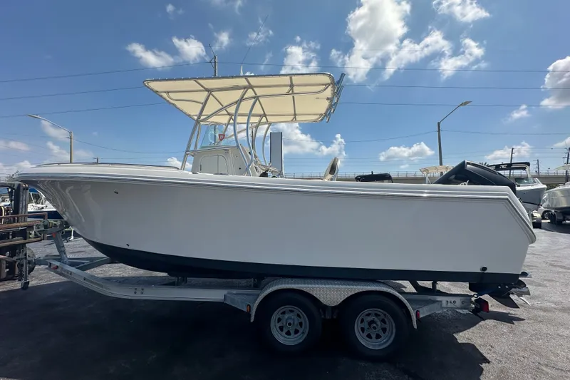 Slide: The Image of 2023 Sailfish 242 CC boat on trailer under blue sky. - 1