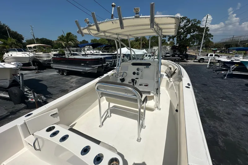 Slide: The Image of 2023 Sailfish 242 CC boat with center console, docked in a marina under clear skies. - 8