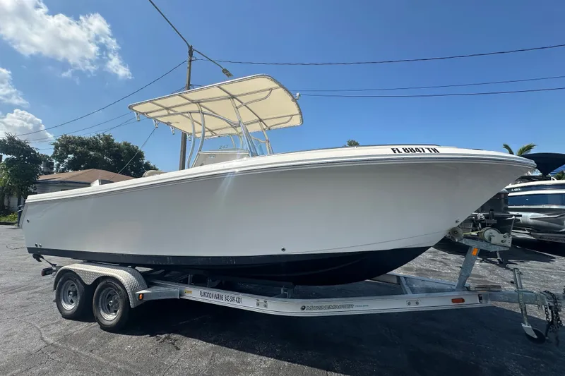 Slide: The Image of 2023 Sailfish 242 CC boat on trailer under clear blue sky. - 6