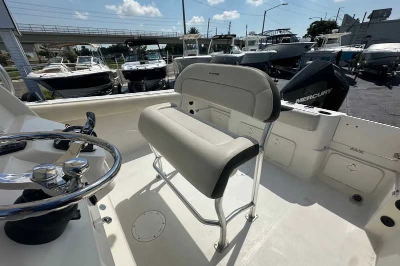 Slide: The Image of 2023 Sailfish 242 CC boat interior with steering wheel and seating. - 11