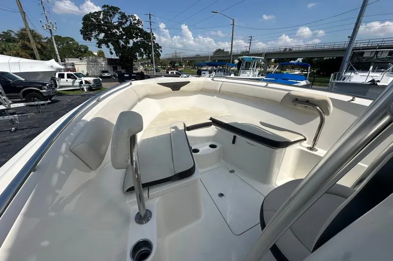 Slide: The Image of 2023 Sailfish 242 CC boat interior with seating and storage, parked outdoors under a clear sky. - 15