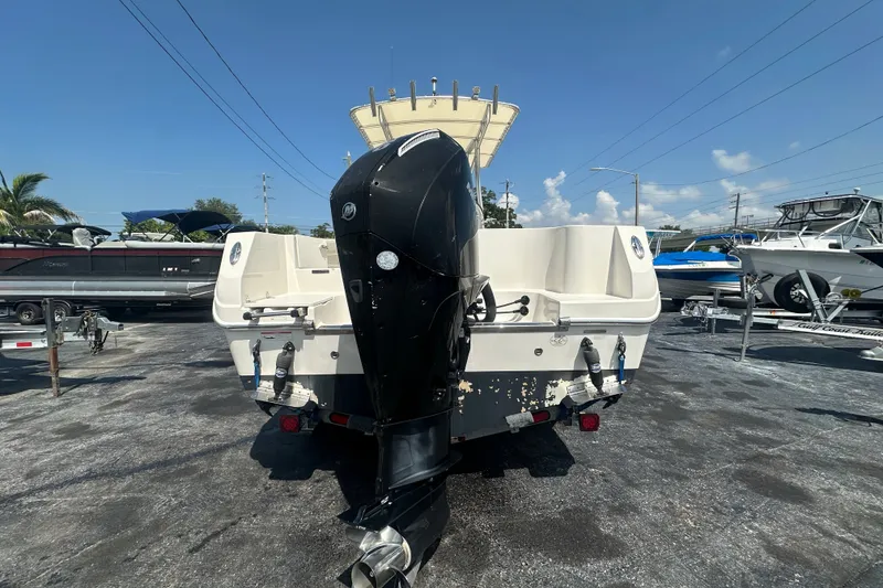 Slide: The Image of 2023 Sailfish 242 CC boat with powerful outboard motor in a marina setting. - 3