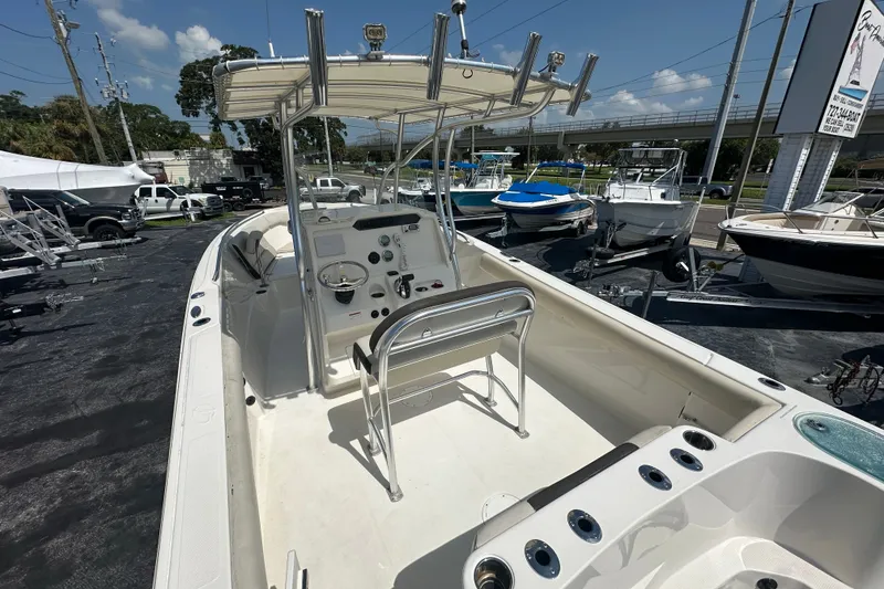 Slide: The Image of 2023 Sailfish 242 CC boat with center console, docked outdoors under clear skies. - 7