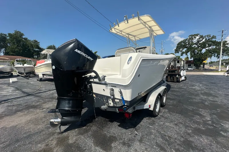 Slide: The Image of 2023 Sailfish 242 CC boat with Mercury engine on a trailer, parked outdoors. - 4