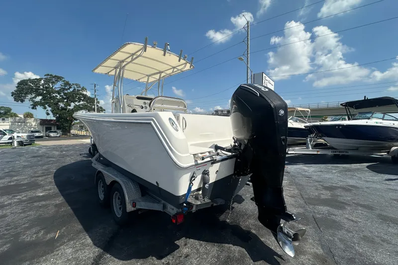 Slide: The Image of 2023 Sailfish 242 CC boat on trailer under clear blue sky. - 2