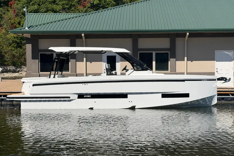 The Image of 2027 De Antonio Yachts D32 docked by a building with a green roof. - 0