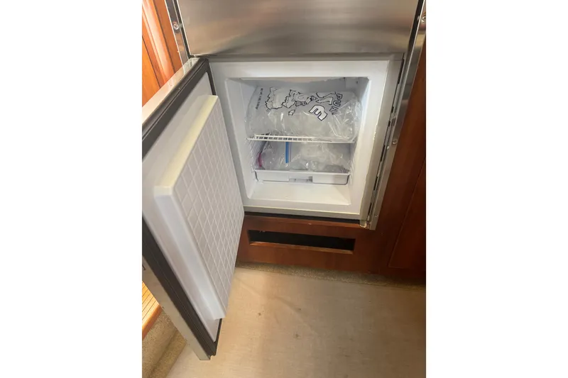 Slide: The Image of Open freezer in 2006 Cruisers Yachts 370 Express, showing ice storage inside. - 25