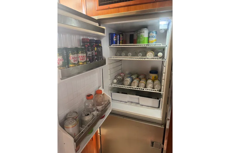 Slide: The Image of Open refrigerator in 2006 Cruisers Yachts 370 Express, stocked with beverages and snacks. - 24