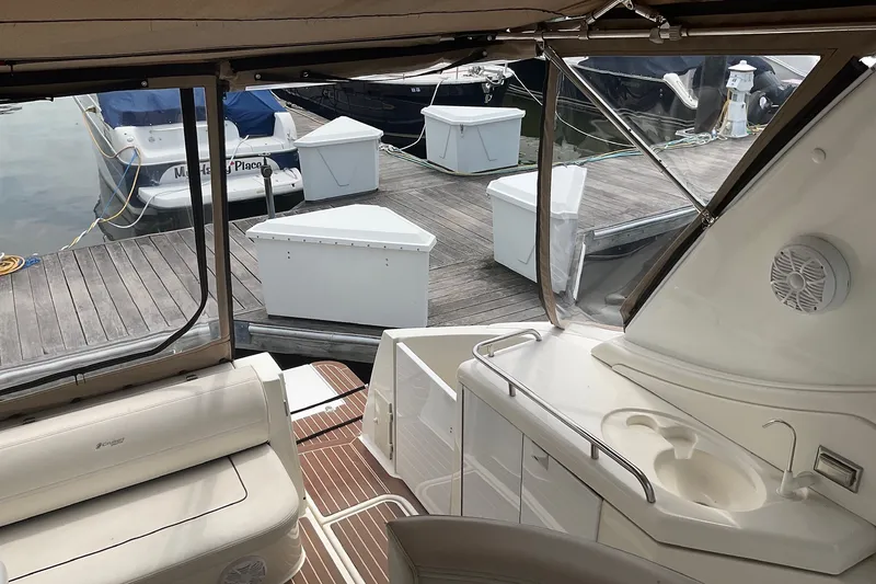 Slide: The Image of 2006 Cruisers Yachts 370 Express interior with dock view, featuring seating and sink area. - 13