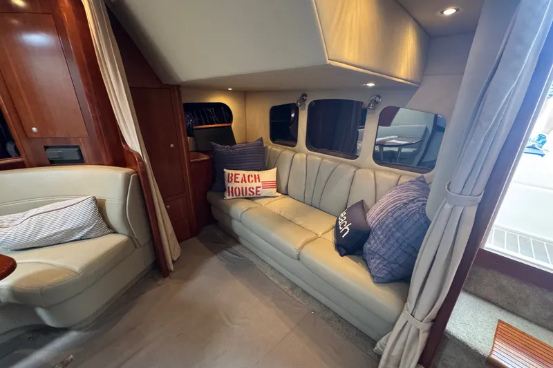 Slide: The Image of Interior of 2006 Cruisers Yachts 370 Express with cozy seating and nautical-themed pillows. - 28