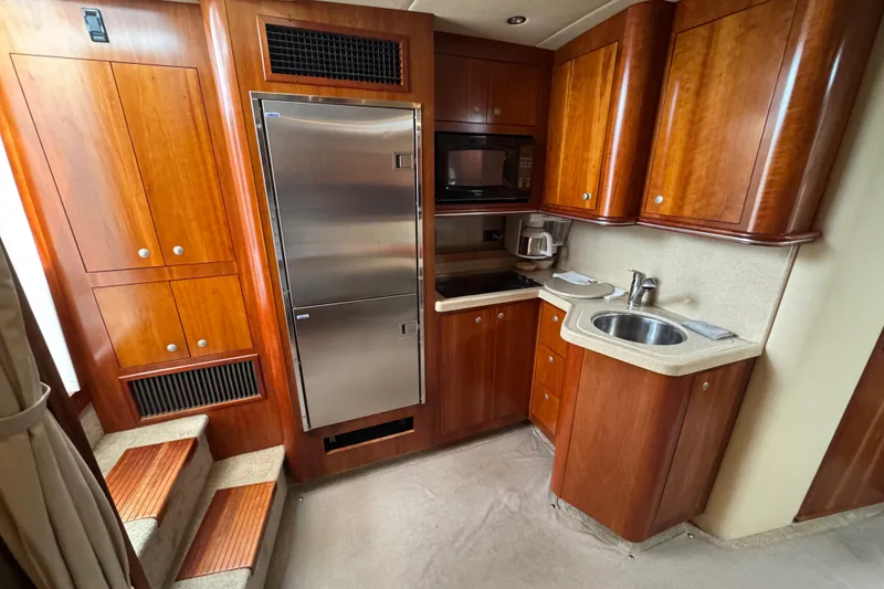 Slide: The Image of 2006 Cruisers Yachts 370 Express kitchen with wood cabinetry and stainless steel appliances. - 26