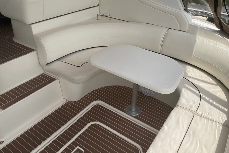 Slide: The Image of Interior seating area of 2006 Cruisers Yachts 370 Express with white upholstery and table. - 10