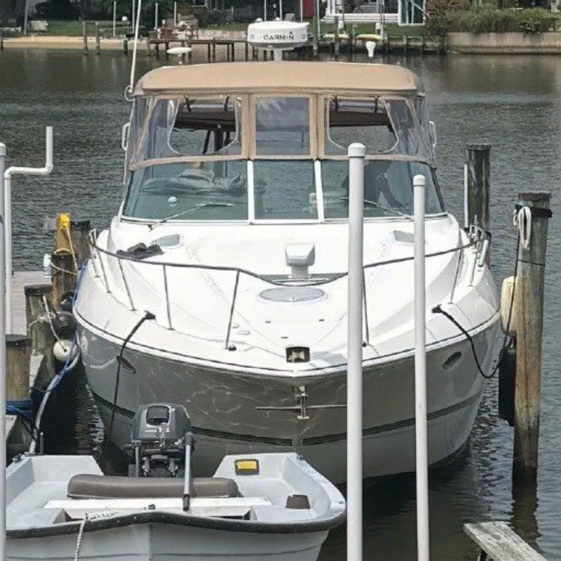 The Image of A 2006 Cruisers Yachts 370 Express docked, featuring a beige canopy. - 0