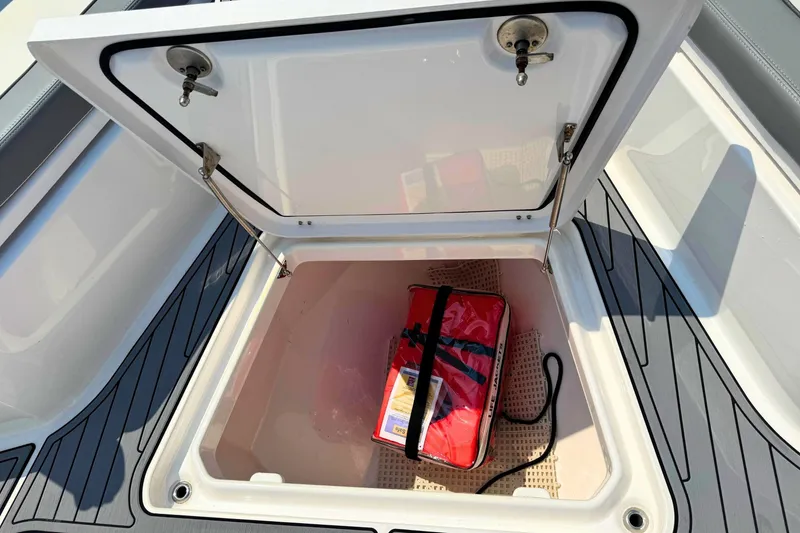 Slide: The Image of Open storage compartment on 2023 Everglades 455 Center Console boat with red bag inside. - 55