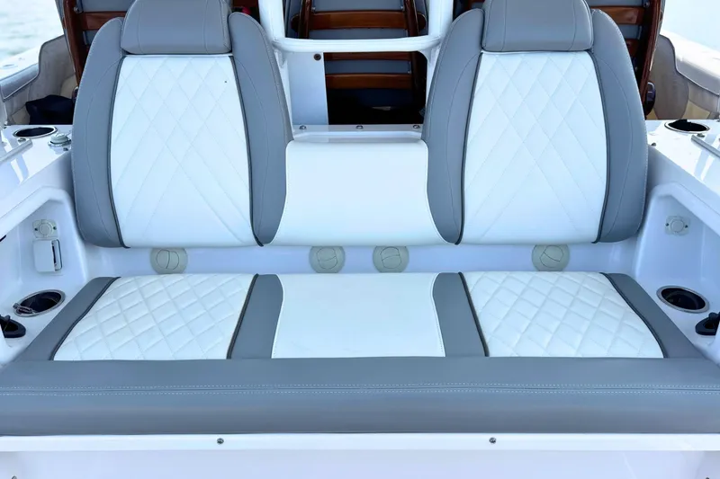 Slide: The Image of 2023 Everglades 455 Center Console boat seating with white and gray upholstery. - 23