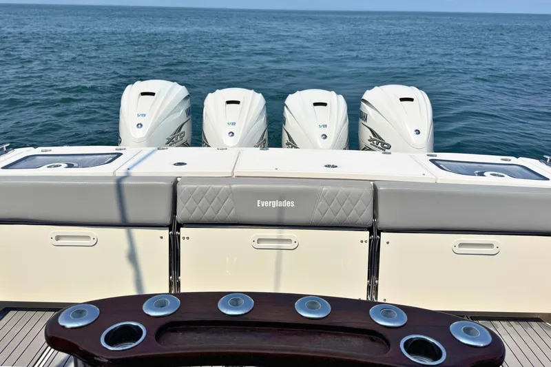 Slide: The Image of 2023 Everglades 455 Center Console boat with four powerful outboard engines on open water. - 11