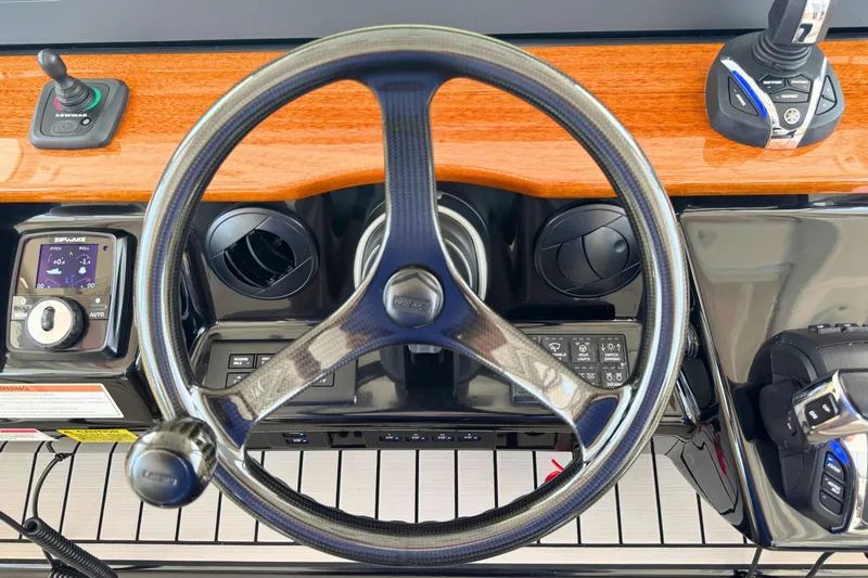 Slide: The Image of 2023 Everglades 455 Center Console helm with steering wheel and control panel. - 34