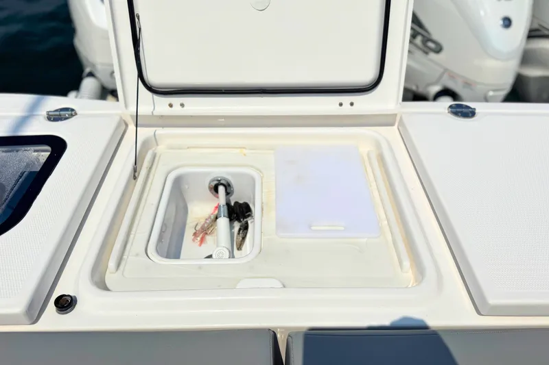Slide: The Image of Open storage compartment on 2023 Everglades 455 Center Console boat, featuring a cutting board. - 65