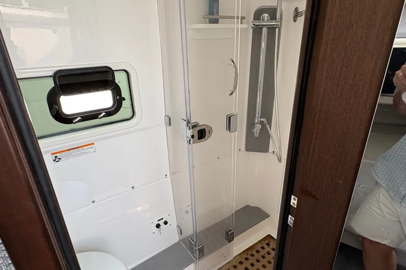 Slide: The Image of Interior of 2023 Everglades 455 Center Console boat featuring a modern shower area. - 42