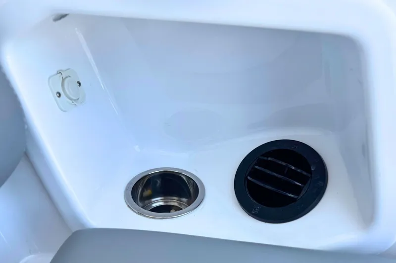 Slide: The Image of 2023 Everglades 455 Center Console boat compartment with cup holder and vent. - 25