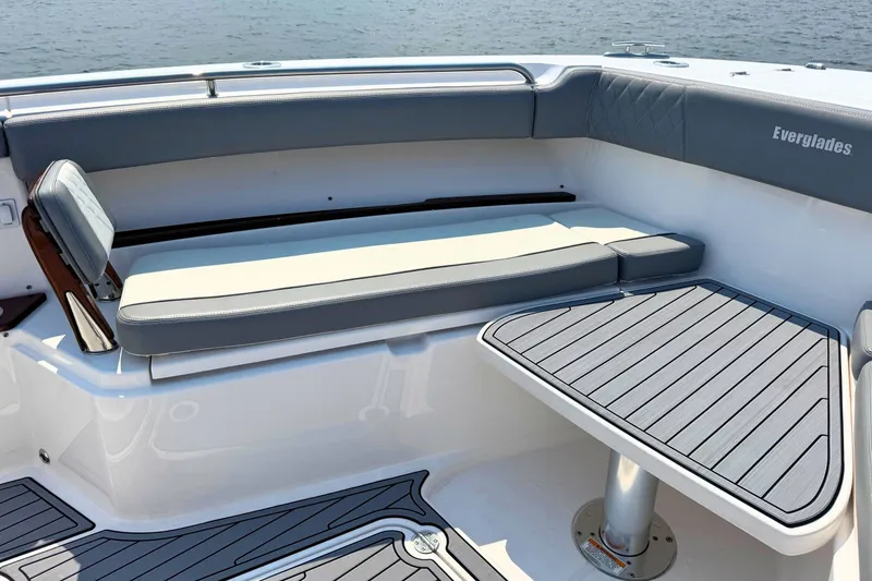 Slide: The Image of 2023 Everglades 455 Center Console boat interior with cushioned seating and table. - 49