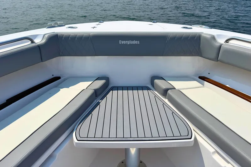 Slide: The Image of 2023 Everglades 455 Center Console boat interior with cushioned seating and table. - 51