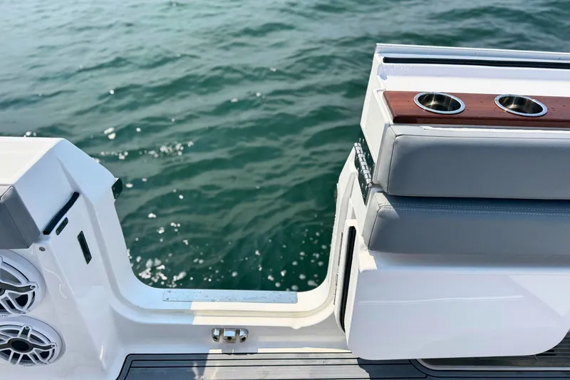 Slide: The Image of 2023 Everglades 455 Center Console boat interior with cup holders, near water. - 14