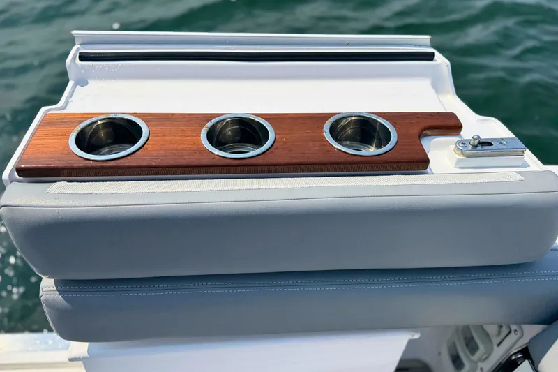Slide: The Image of 2023 Everglades 455 Center Console boat with wooden cup holders on a cushioned seat. - 15