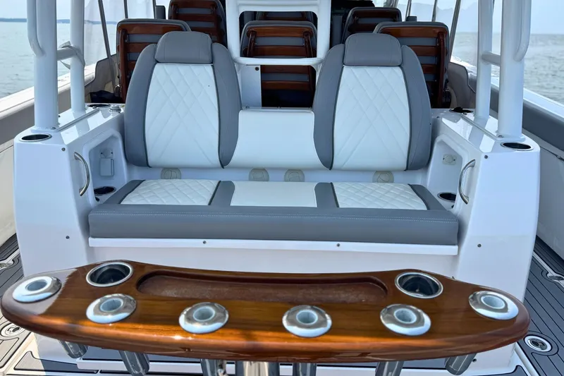 Slide: The Image of 2023 Everglades 455 Center Console boat interior with cushioned seating and rod holders. - 20