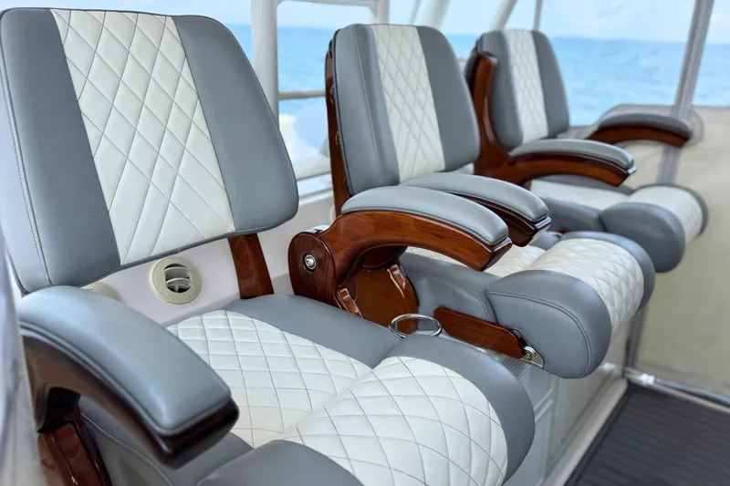 Slide: The Image of Luxurious seating on 2023 Everglades 455 Center Console boat with quilted upholstery and wooden armrests. - 29