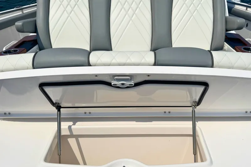 Slide: The Image of 2023 Everglades 455 Center Console boat with open storage compartment and cushioned seating. - 48