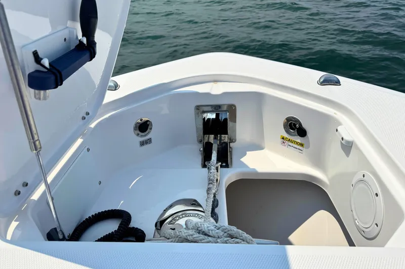 Slide: The Image of 2023 Everglades 455 Center Console anchor compartment with rope and winch, open hatch view. - 53