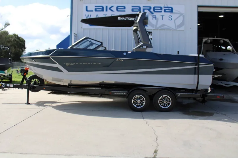 The Image of The image shows a modern motorboat on a trailer in front of a building. - 1