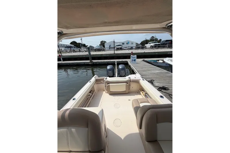 Slide: The Image of 2013 Grady-White Freedom 255 boat docked, showcasing spacious seating and twin engines. - 16