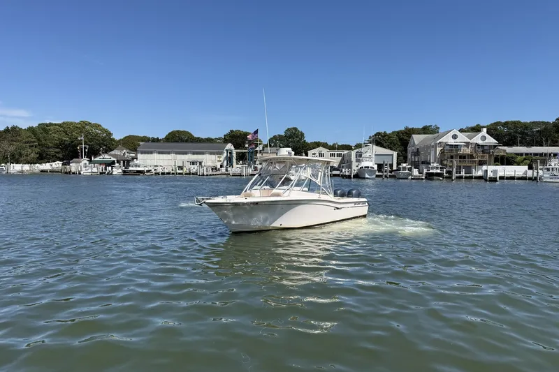 Slide: The Image of 2013 Grady-White Freedom 255 boat cruising in a scenic harbor setting. - 4