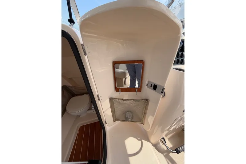 Slide: The Image of 2013 Grady-White Freedom 255 boat interior with mirror and storage compartment. - 19