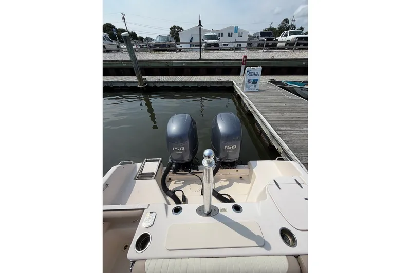 Slide: The Image of 2013 Grady-White Freedom 255 boat with twin 150 horsepower engines docked at marina. - 23