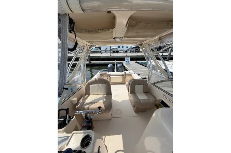Slide: The Image of 2013 Grady-White Freedom 255 boat interior with seating and helm, docked at marina. - 20