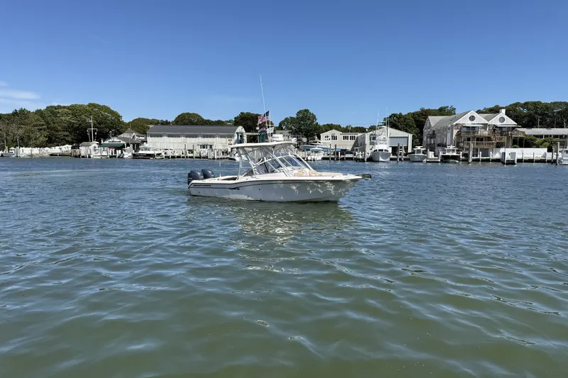 The Image of 2013 Grady-White Freedom 255 boat on calm water near marina. - 0