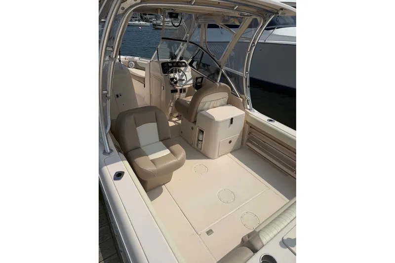 Slide: The Image of 2013 Grady-White Freedom 255 boat interior with beige seating and steering console. - 12